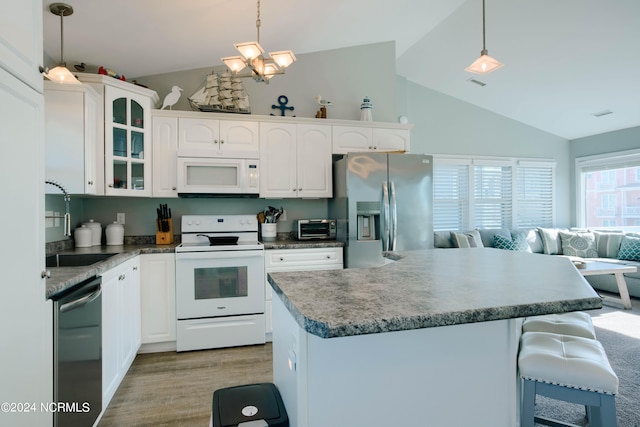 kitchen with white cabinets, stainless steel appliances, and hanging light fixtures