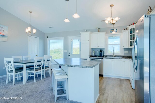 kitchen with white cabinets, decorative light fixtures, and appliances with stainless steel finishes