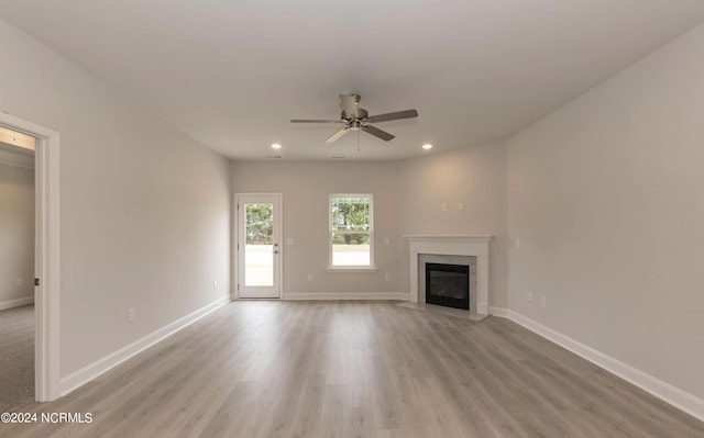 unfurnished living room featuring baseboards, wood finished floors, and recessed lighting