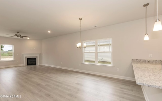 unfurnished living room featuring a fireplace, light wood-style flooring, and baseboards