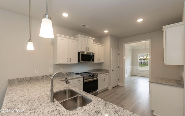 kitchen featuring a sink, visible vents, light wood-style floors, white cabinets, and appliances with stainless steel finishes