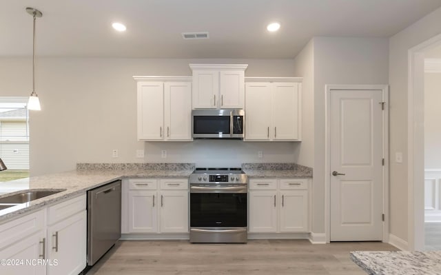 kitchen featuring a sink, visible vents, white cabinetry, appliances with stainless steel finishes, and light wood finished floors