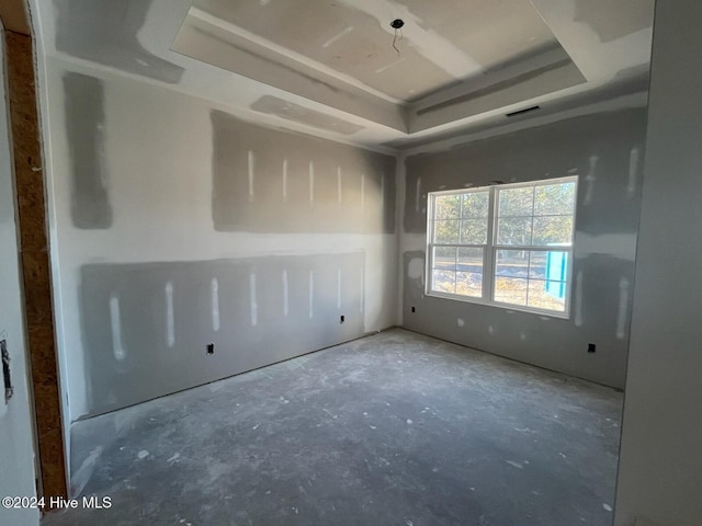 spare room with a tray ceiling and visible vents