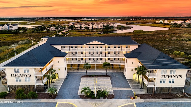 aerial view at dusk featuring a water view