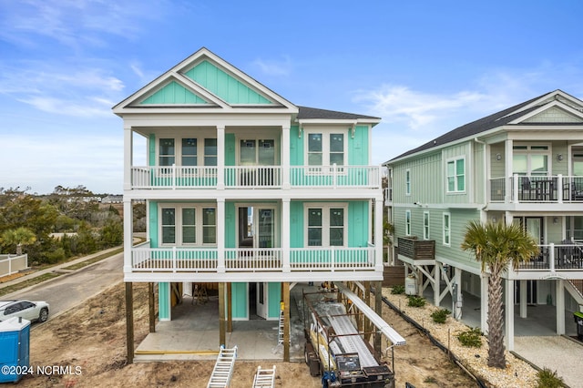 back of house featuring a balcony and a carport