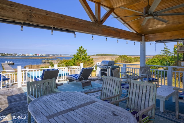 deck featuring a water view, ceiling fan, and a grill