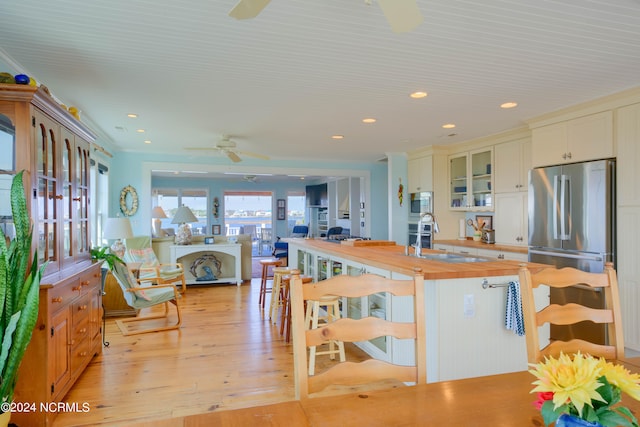 kitchen with ceiling fan, sink, wooden counters, light hardwood / wood-style flooring, and stainless steel refrigerator