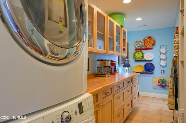 kitchen with stacked washer / dryer and light tile patterned floors