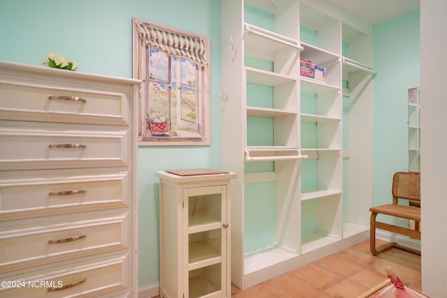 walk in closet with light tile patterned floors