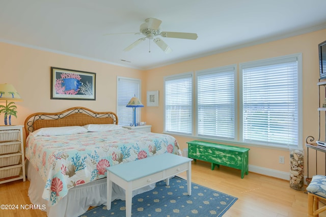 bedroom with light wood-type flooring, multiple windows, ceiling fan, and crown molding