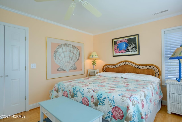 bedroom with light hardwood / wood-style floors, a closet, ceiling fan, and crown molding