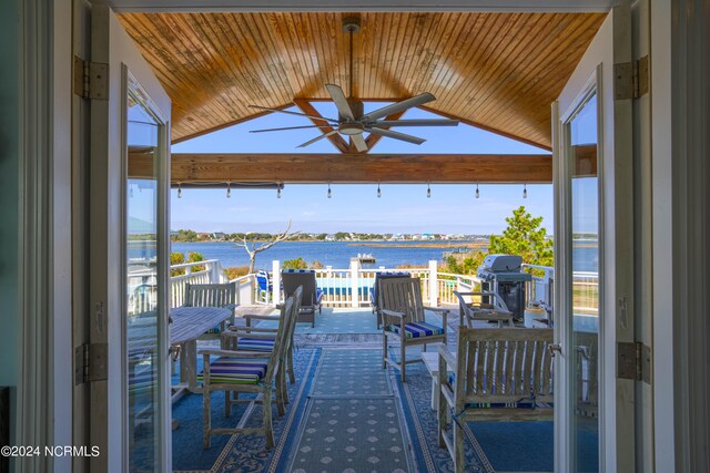 view of patio with a water view, area for grilling, ceiling fan, and an outdoor hangout area