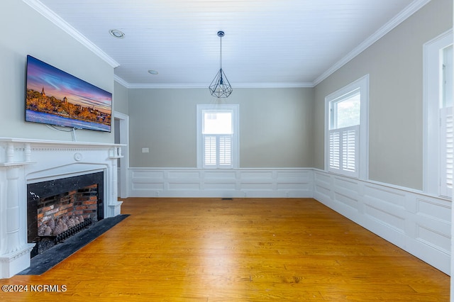 unfurnished living room with crown molding, hardwood / wood-style floors, and a healthy amount of sunlight