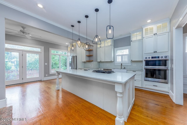 kitchen with white cabinets, a center island, and light wood-type flooring