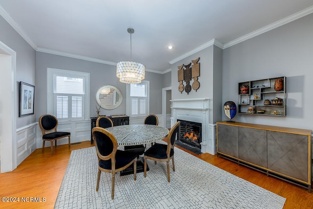 dining room with a chandelier, hardwood / wood-style floors, and crown molding