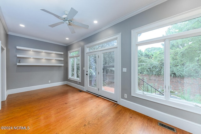 interior space featuring light hardwood / wood-style flooring, a wealth of natural light, ceiling fan, and ornamental molding