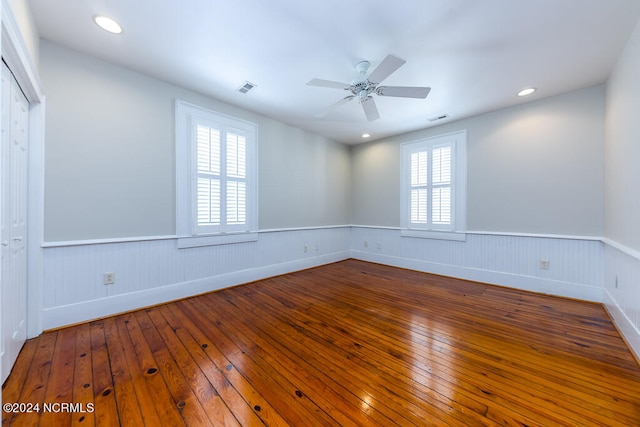 unfurnished room with a healthy amount of sunlight, wood-type flooring, and ceiling fan