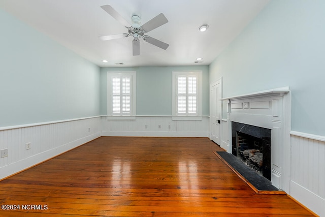 unfurnished living room with dark hardwood / wood-style flooring and ceiling fan