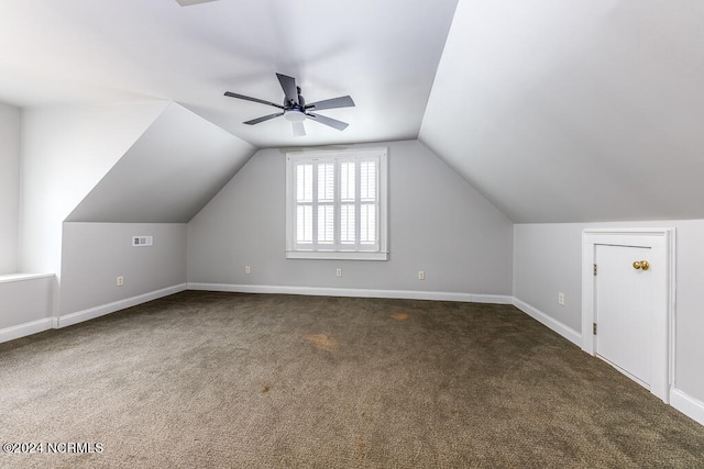 additional living space featuring dark colored carpet, ceiling fan, and vaulted ceiling