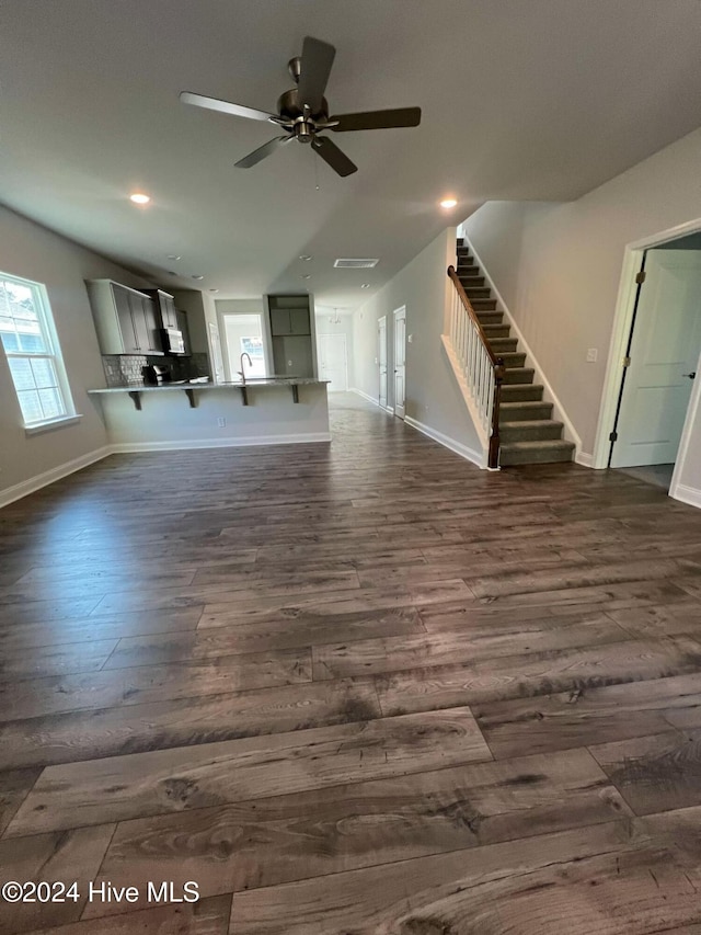 unfurnished living room featuring dark hardwood / wood-style floors and ceiling fan