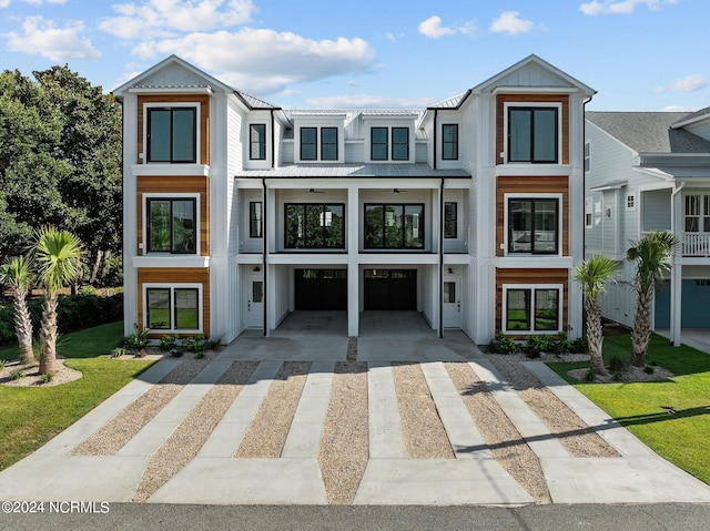 view of property featuring a balcony and a front lawn