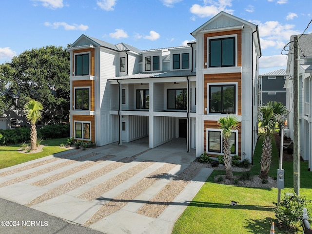 multi unit property featuring a front lawn and a carport