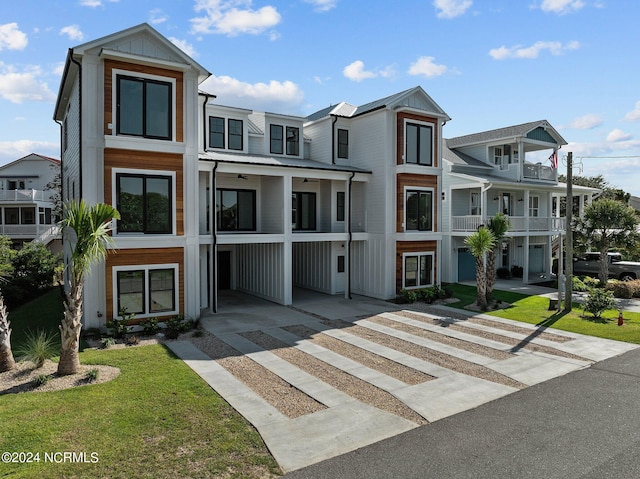 view of property featuring a balcony and a front lawn