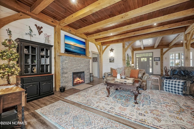 living room featuring beam ceiling, a fireplace, wood ceiling, and dark hardwood / wood-style flooring