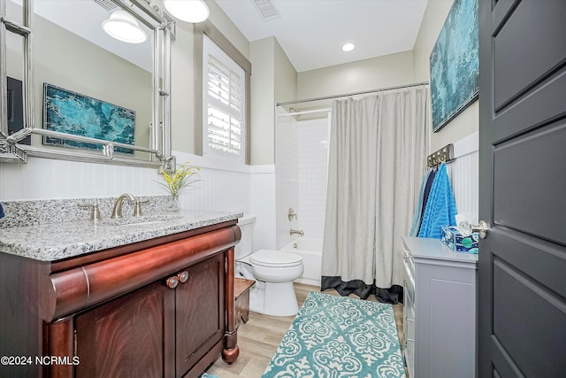 full bathroom with shower / tub combo, vanity, wood-type flooring, and toilet