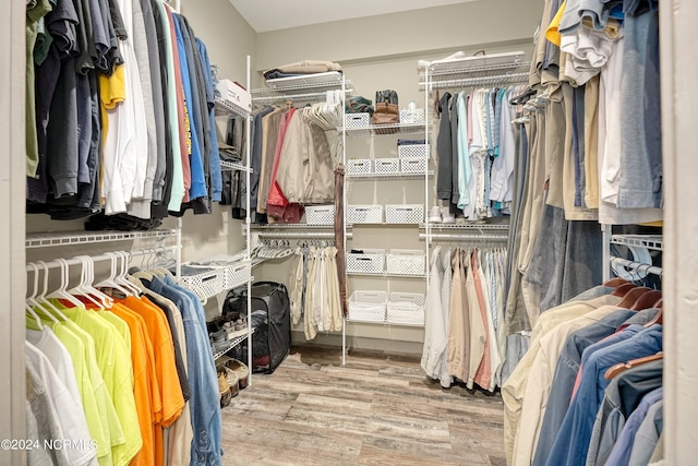 walk in closet with light hardwood / wood-style floors