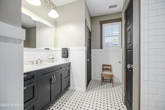 bathroom featuring tile flooring, large vanity, tasteful backsplash, and tile walls