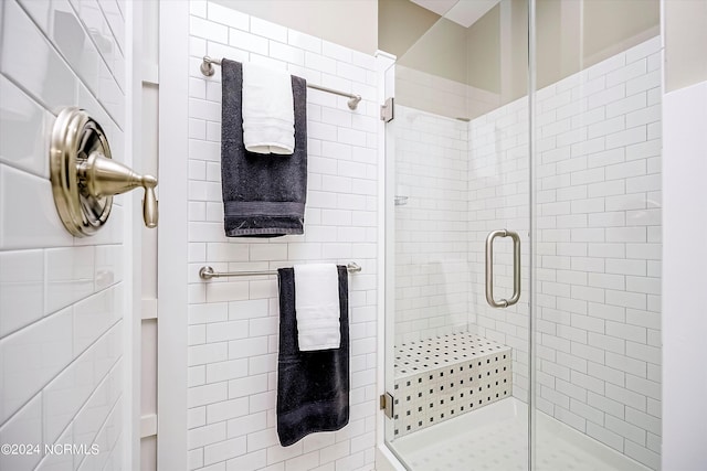 bathroom featuring tile walls and a shower with door