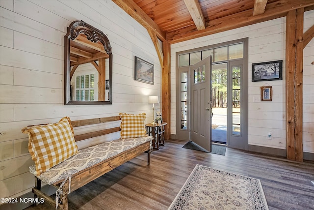 foyer entrance with dark hardwood / wood-style flooring, wood ceiling, beam ceiling, and wood walls