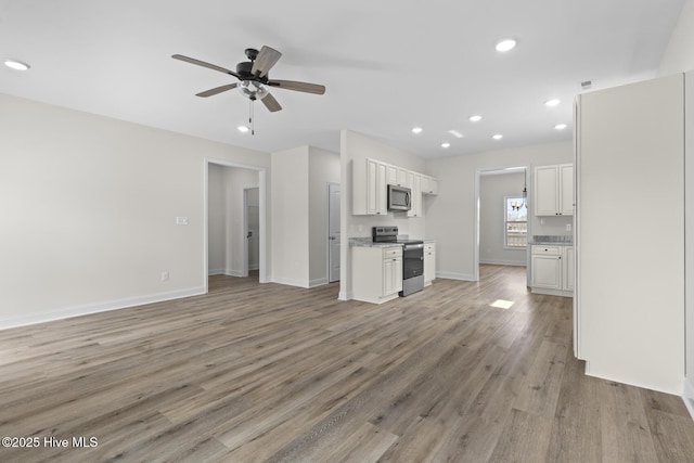 unfurnished living room with recessed lighting, baseboards, light wood-style floors, and a ceiling fan