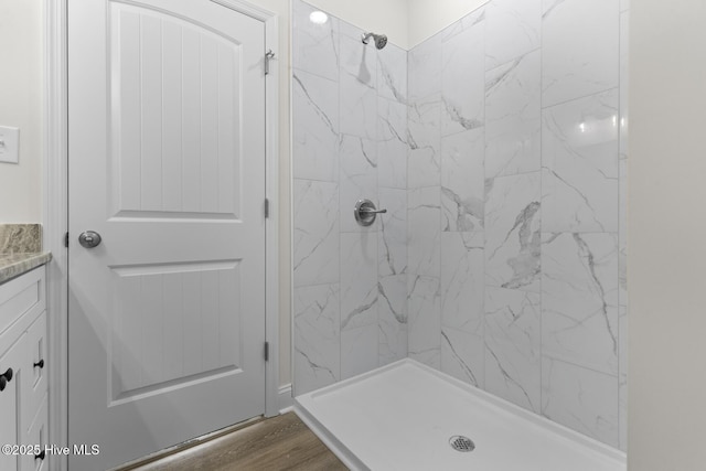 bathroom with vanity, wood finished floors, and a shower stall