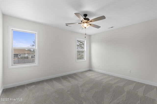 empty room with visible vents, ceiling fan, baseboards, and carpet floors