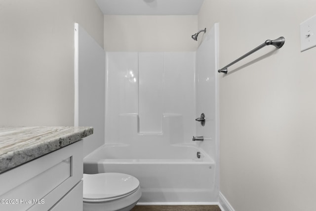 bathroom with bathtub / shower combination, toilet, vanity, and baseboards