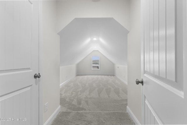 bonus room with baseboards, lofted ceiling, and carpet