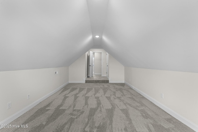 bonus room featuring light carpet, lofted ceiling, and baseboards