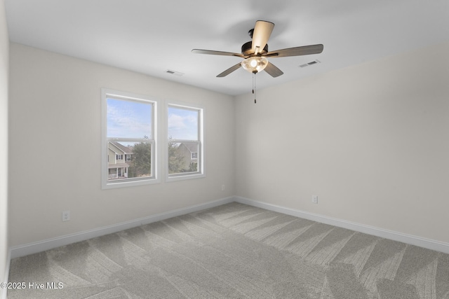 empty room with visible vents, baseboards, light colored carpet, and ceiling fan