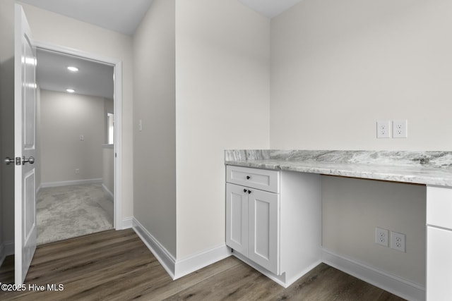 hallway with dark wood-style floors and baseboards