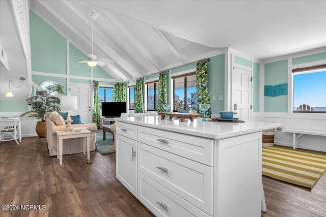 kitchen with a healthy amount of sunlight, a center island, white cabinets, and dark hardwood / wood-style floors