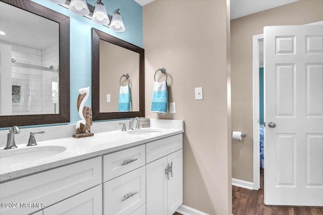 bathroom with a shower with door, vanity, and wood-type flooring