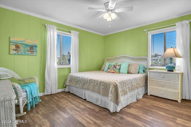 bedroom featuring dark wood-type flooring, ornamental molding, and ceiling fan