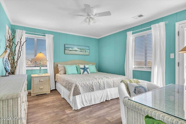 bedroom with hardwood / wood-style flooring, ceiling fan, and crown molding