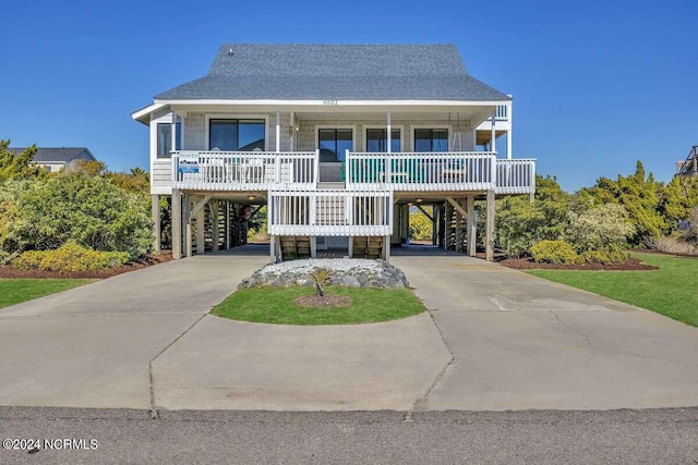 coastal inspired home featuring a carport and a porch