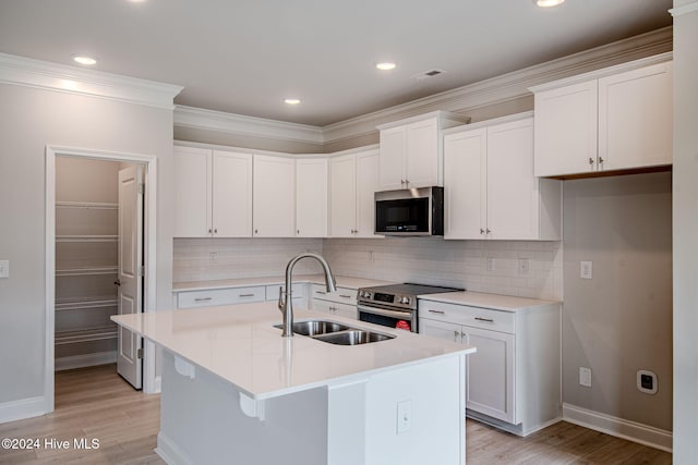 kitchen featuring white cabinetry, an island with sink, and appliances with stainless steel finishes