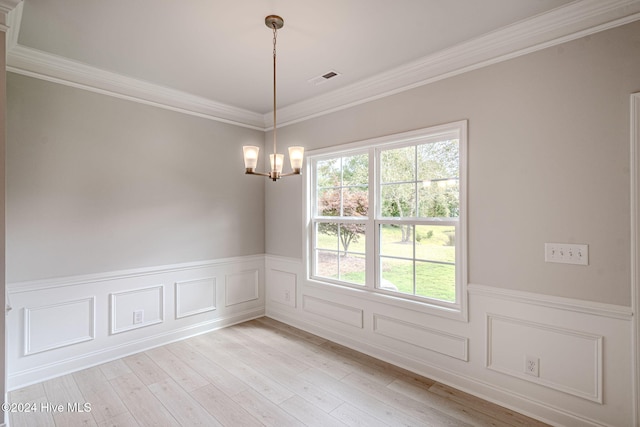 empty room featuring ornamental molding, light hardwood / wood-style floors, and a notable chandelier