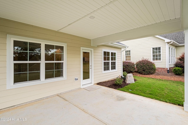 view of exterior entry with a patio area