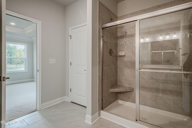 bathroom with tile patterned floors, a shower with door, and ornamental molding